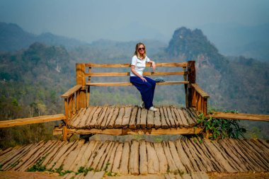 woman posing against mountains, Thailand  clipart