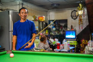 Bangkok, Tayland - 29 Mart 2019: Mutlu ve gülümseyen Asyalı adamlar Bangkok, Tayland 'ın yoksul bir mahallesinde bilardo oynuyorlar