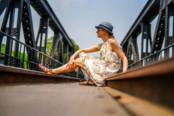 Junge Frau Mit Hut Und Sonnenbrille Sitzt Auf Der Brücke — Stockfoto