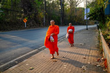 Pai, Tayland - 23 Mart 2019: Çin Budist rahipleri beline kırmızı bornozla bağlanmış huzur dolu bir Çin Kültür Köyünde yürüyorlar.