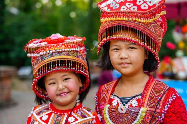 Chiang Mai, Tayland - 21 Mart 2019 Wat Phrathat tapınağının merdivenlerinde geleneksel kırmızı kıyafetler ve şapkalar giyen gülen Hmong kabilesi kızları, Chiang Mai, Tayland, Southea 'daki Doi Suthep dağları