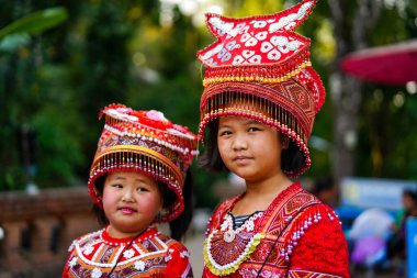 Chiang Mai, Tayland - 21 Mart 2019 Wat Phrathat tapınağının merdivenlerinde geleneksel kırmızı kıyafetler ve şapkalar giyen gülen Hmong kabilesi kızları, Chiang Mai, Tayland, Southea 'daki Doi Suthep dağları