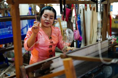 Chiang Mai, Tayland - 22 Mart 2019: Eski geleneksel tekerlek makinesiyle ipek fabrikasında çalışan kadın