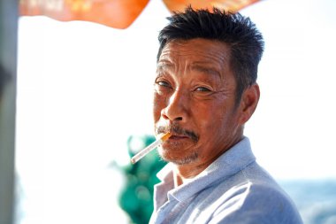 Koh Samui, Tayland - 3 Nisan 2019: Koh Samui, Tayland 'da sigara içen taksi şoförü Asyalı adamın portresi