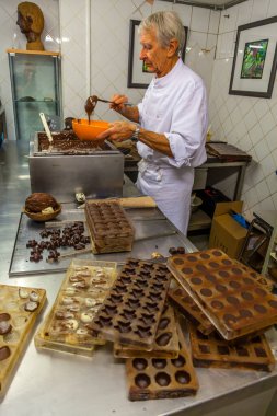 BRÜKSEL, BELGIUM - 1 Ocak 2020: Brüksel, Belçika 'daki çikolata müzesinde kakao çekirdekleri, kakao kabukları ve çikolata kalıplarıyla çikolata sunumu yapan çikolatalı şekerci