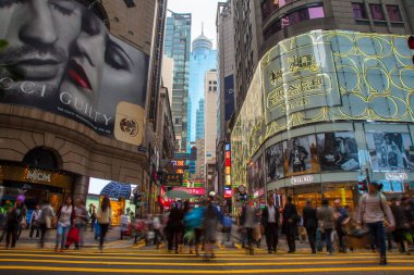 Hong Kong şehir merkezinden geçen kalabalık şehir şehrinde trafik yolu ve binalar, Hong Kong şehir merkezinden geçen sarı zebra. Yoldan geçen yayalar, alışveriş merkezlerinin yakınından geçiyor.