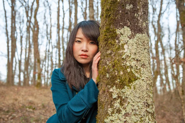 在美丽的森林里的一棵树后画上美丽的亚洲女人的肖像 — 图库照片