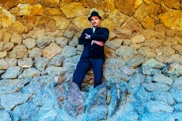 Mann Posiert Gegen Uralte Felswand — Stockfoto