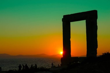 Apollo Tapınağı 'nın Cyclades, Yunanistan' daki Naxos 'taki girişi çok güzel bir günbatımıyla. Naxos 'un Portarası taştan yapılmış bir anıt gibi güzel bir çerçevedir..