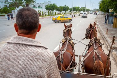 SOUSSE, TUNISIA - 7 HAZİRAN 2020: Şehir merkezindeki bir yolda at çizilmiş bir kaleye binen yaşlı adam