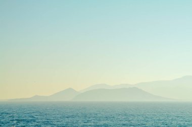 Mavi deniz dalgası ve küçük adalı mavi gökyüzü 