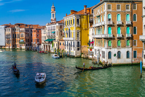 VENICE, ITALY - JANUARY 16, 2020: Gondolas sailing on Venice canal, famous Venetian monuments and architecture. Romantic and beautiful city of Venice.