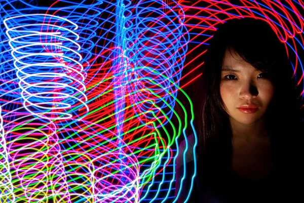 Portrait of woman with led light painting. Creative long exposure photography. Symbol of technology, science, future, energy and speed