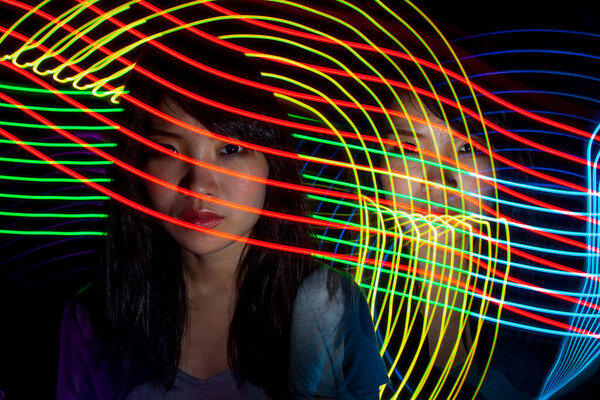 Portrait of woman with led light painting. Creative long exposure photography. Symbol of technology, science, future, energy and speed