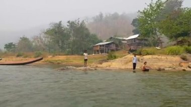 Mae Hong Son, Tayland - 25 Mart 2019: Uzun boyunlu bir kabilenin uzak köyü. Tayland 'daki etnik azınlığın çocukları nehir kıyısında merhaba diyor..