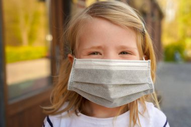 Yüz maskesi takan küçük bir kızın portresi, Coronavirus salgını dünya çapında kriz