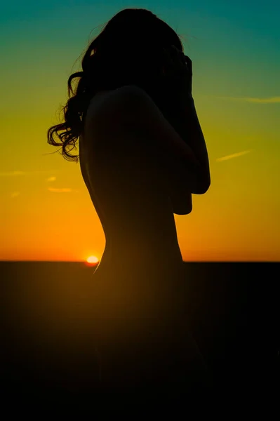 silhouette of beautiful woman in sunset field