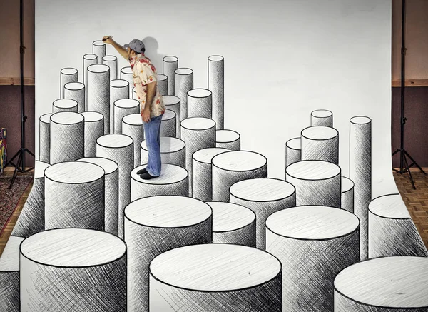 Young man drawing giant 3D cylinders. Anamorphose drawing.