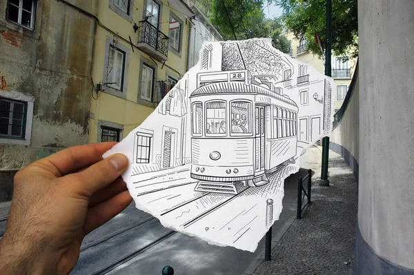 写真の背景にアパートのある街の路面電車を描いた鉛筆で描いた手作りの紙を示す混在メディアイメージ — ストック写真