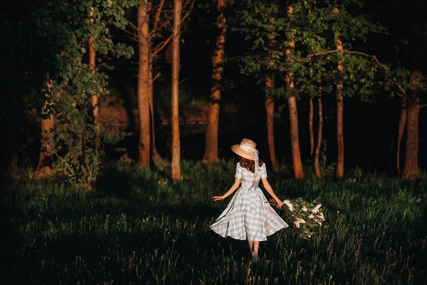 Menina bonita desfrutando o cheiro de lilás em um dia de verão. Aromaterapia e conceito de primavera. Uma menina bonita, uma mulher bonita em um vestido longo azul do vintage está de pé em um jardim lilás. Jardinagem — Fotografia de Stock