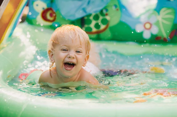 Niño juega en la piscina. Niña en la piscina, niña sonriente — Foto de Stock