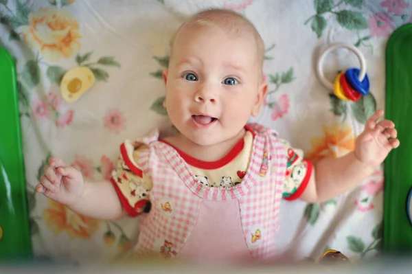 Charming little girl smiles and plays with toys. — Stock Photo, Image