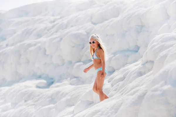 Дівчина в купальнику і сонцезахисні окуляри на білій горі, сонячний день — стокове фото