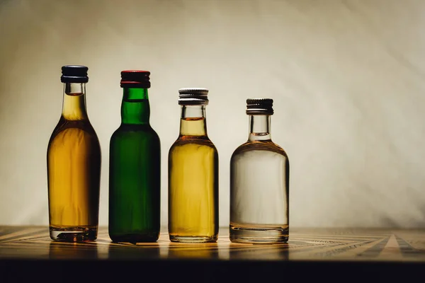 Different alcohol bottles are on the table on a light background Royalty Free Stock Images
