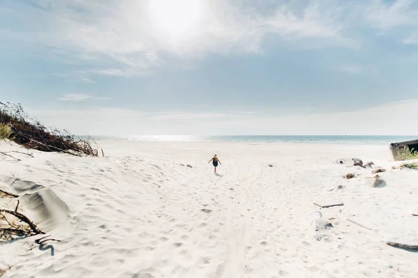 Das Kind rennt am weißen Strand entlang der Ostsee. — Stockfoto