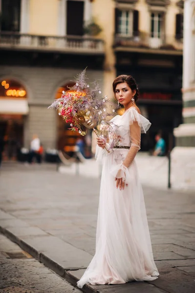 A menina-noiva é com belo padrão de flores como uma máscara em Florença, noiva elegante em um vestido de noiva de pé com uma máscara na cidade velha de Florença. Menina modelo em Florença — Fotografia de Stock