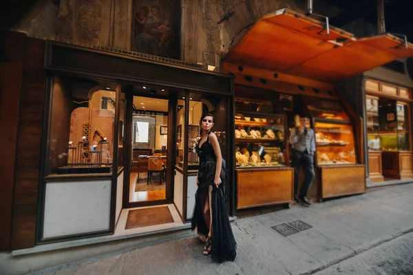 Красивая стильная невеста в черном платье ходит по Флоренции, модель в черном платье в старом городе Италии — стоковое фото