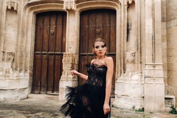 En snygg brud i svart bröllopsklänning poserar i den gamla franska staden Avignon. Modell i svart klänning. Påvepalatset i Avignon, Provence. — Stockfoto