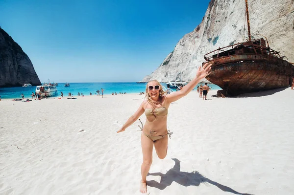 Woman relaxing on the famous Shipwreck Navagio beach in Zakynthos Greece