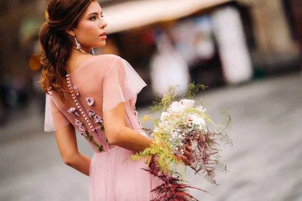 一位年轻漂亮的新娘站在意大利佛罗伦萨古城的中心 在托斯卡纳 新娘穿着漂亮的粉色连衣裙 戴着一束鲜花 意大利 — 图库照片
