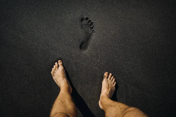 Zbliżenie Męskich Odcisków Stóp Stóp Spacerujących Wulkanicznym Czarnym Piasku Plaży — Zdjęcie stockowe