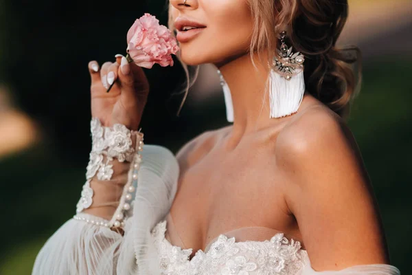 女性の手の中で何度もバラや花嫁の手数料朝の花嫁白いドレスイヤリングをつけて — ストック写真