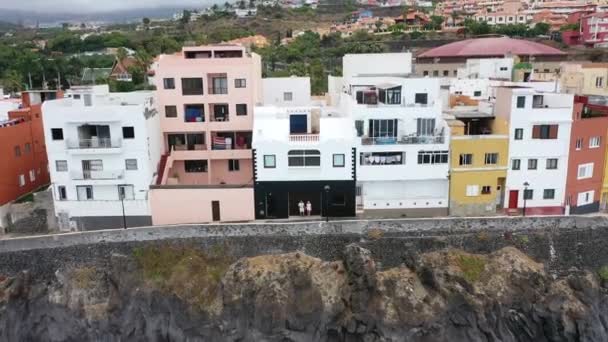 Gyönyörű lány és férfi fehér pólóban és rövidnadrágban egy falnak támasztva Puerto de La Creuse-ban, Tenerife államban. — Stock videók