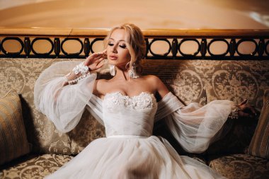 Güzel Gelin Portresi makyajı, düğün saç stili, gelinlik. İç kısımda çok güzel bir gelin var. Genç ve güzel gelinin yakın plan portresi. Düğün için. Gelin küpelere dokunur..