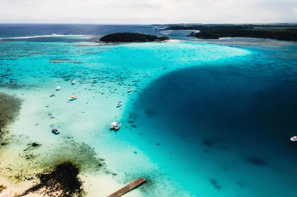 毛里求斯岛东海岸的航空摄影。毛里求斯岛上的蓝色泻湖被从上面射穿了。小船在碧绿的湖上漂浮着 — 图库照片