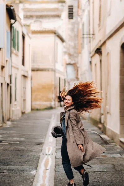 一个穿着外套 头发低垂的美丽而浪漫的女孩穿过了阿维尼翁古城 在法国穿外套的女孩 — 图库照片