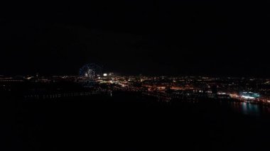 Minsk şehrinin kuş bakışı görüntüsünden havai fişek ve havai fişek gösterisi. Avrupa 'da bir nehrin üzerinde gökyüzündeki renkli ışıklar. Kutlama selamı. Zafer günü 9 Mayıs