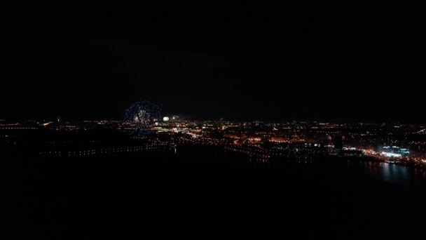 Vista de fuegos artificiales y fuegos artificiales desde una vista de pájaro sobre la ciudad de Minsk. Luces de colores en el cielo sobre un río en Europa. Un saludo festivo. Día de la victoria 9 de mayo — Vídeos de Stock