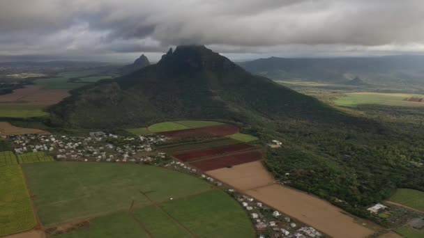 Аэрофотосъемка красивой зеленой сельской местности Маврикия с полем и видом на горы . — стоковое видео