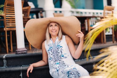 Gülümseyen kızıl saçlı kadın. Büyük şapkalı güzel kız ve beyaz gömlek gülümsüyor..