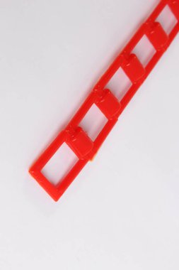 Beyaz zemin üzerinde kırmızı plastik zincir