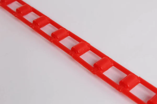 Beyaz zemin üzerinde kırmızı plastik zincir