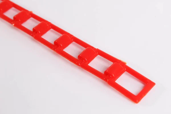 Beyaz zemin üzerinde kırmızı plastik zincir