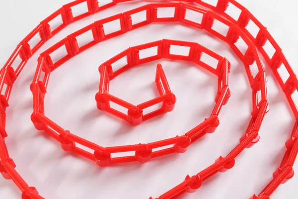 Beyaz zemin üzerinde kırmızı plastik zincir
