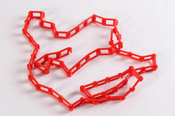 Beyaz zemin üzerinde kırmızı plastik zincir