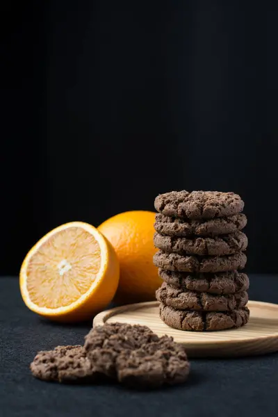 Cookies with orange zest on a dark table.